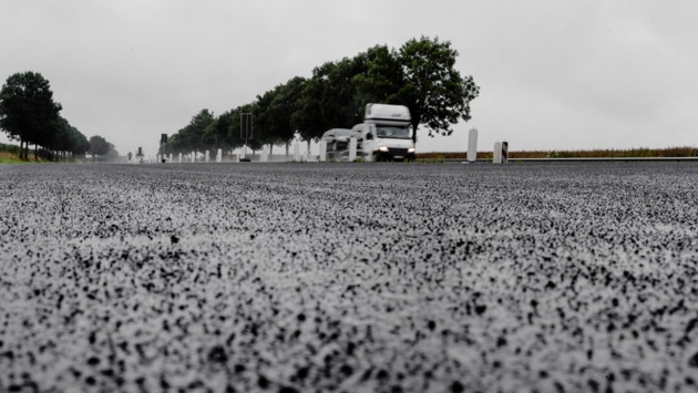 Ein Auto fährt an einer Baustelle entlang.