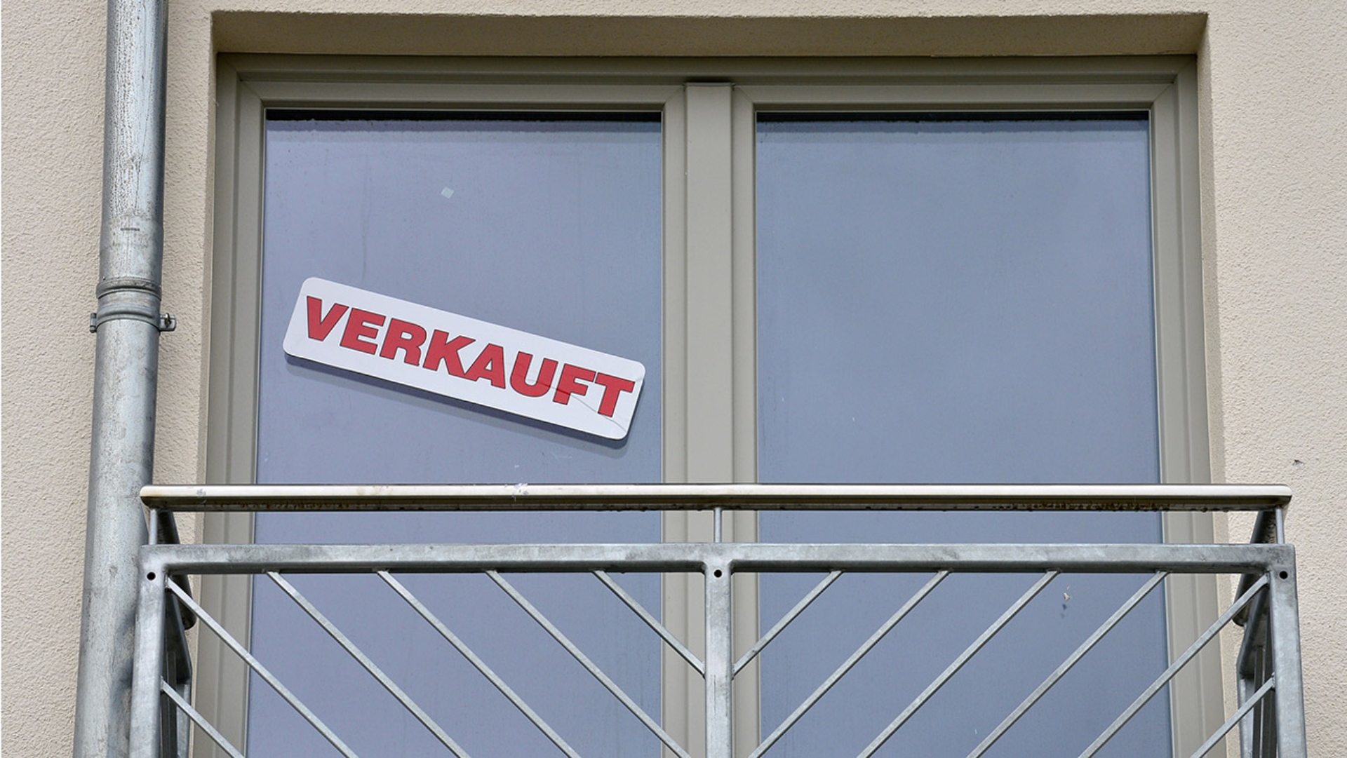 Ein «Verkauft» Hinweis ist an einem Wohnhaus an die Scheibe geklebt. 