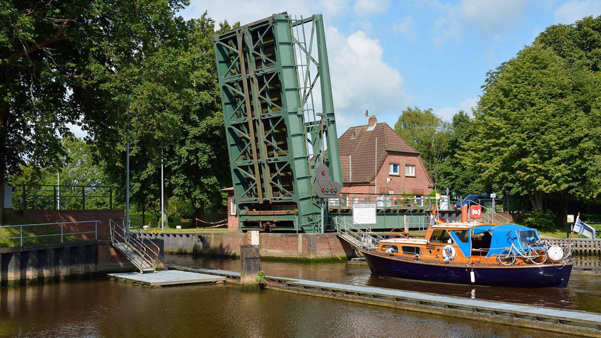 Ein Boot liegt vor einer Schleuse mit geöffnetem Schleusentor.