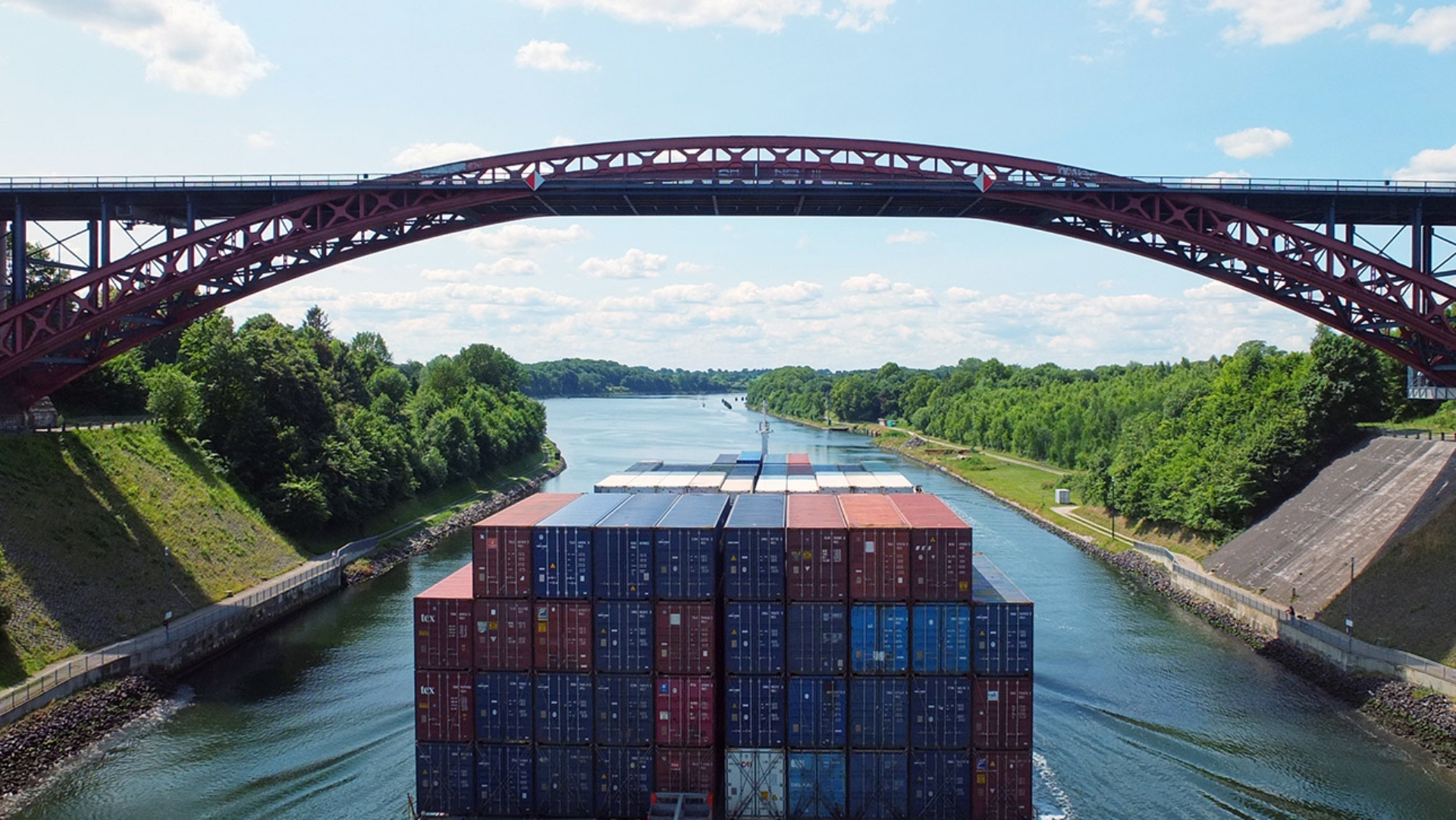 Ein Containerschiff fährt auf dem Nord-Ostsee-Kanal mit Blick auf die Levensauer Hochbrücke bei Kiel.