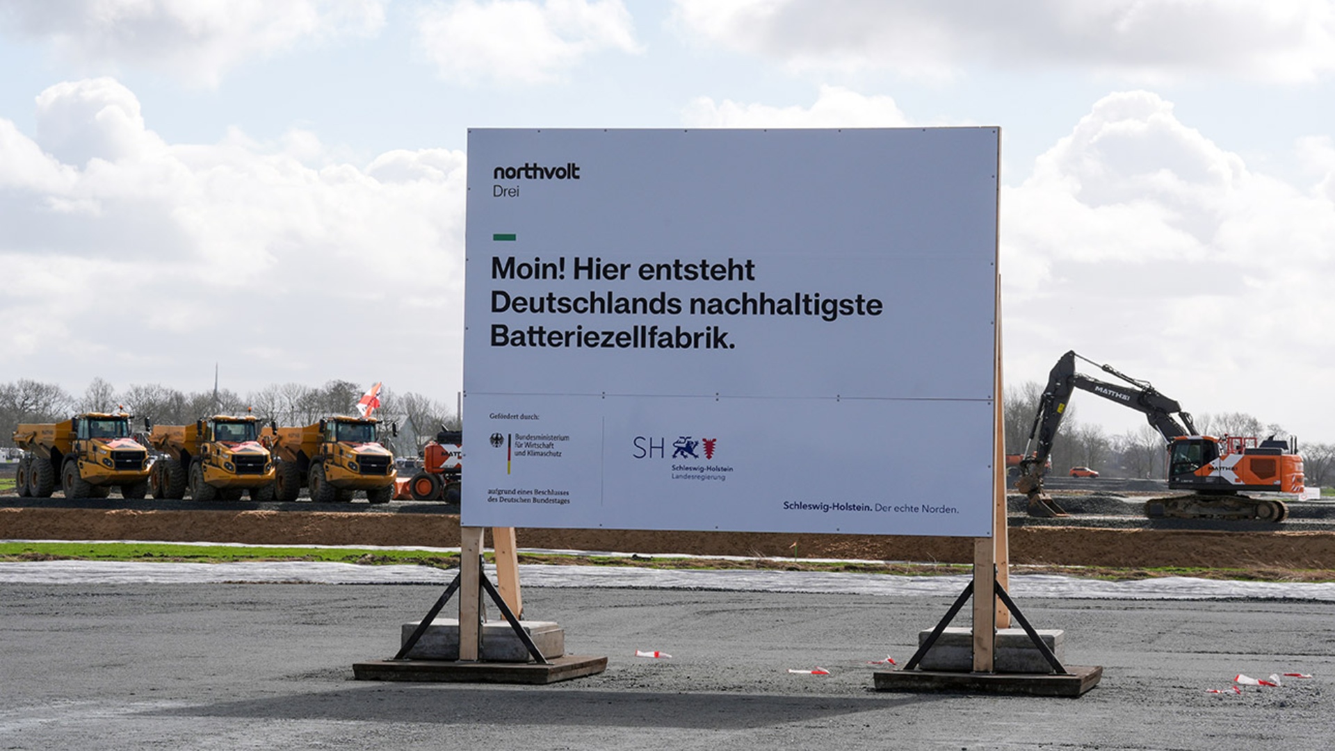 Ein Bauschild steht zu Baubeginn auf dem Gelände der Batteriefabrik des schwedischen Unternehmens Northvolt bei Heide 