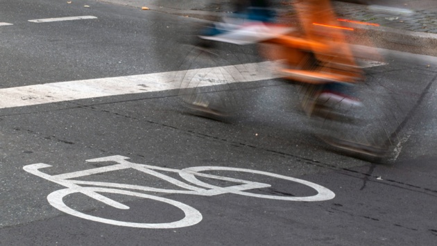 Ein Fahrradfahrer fährt über einen Radweg. 