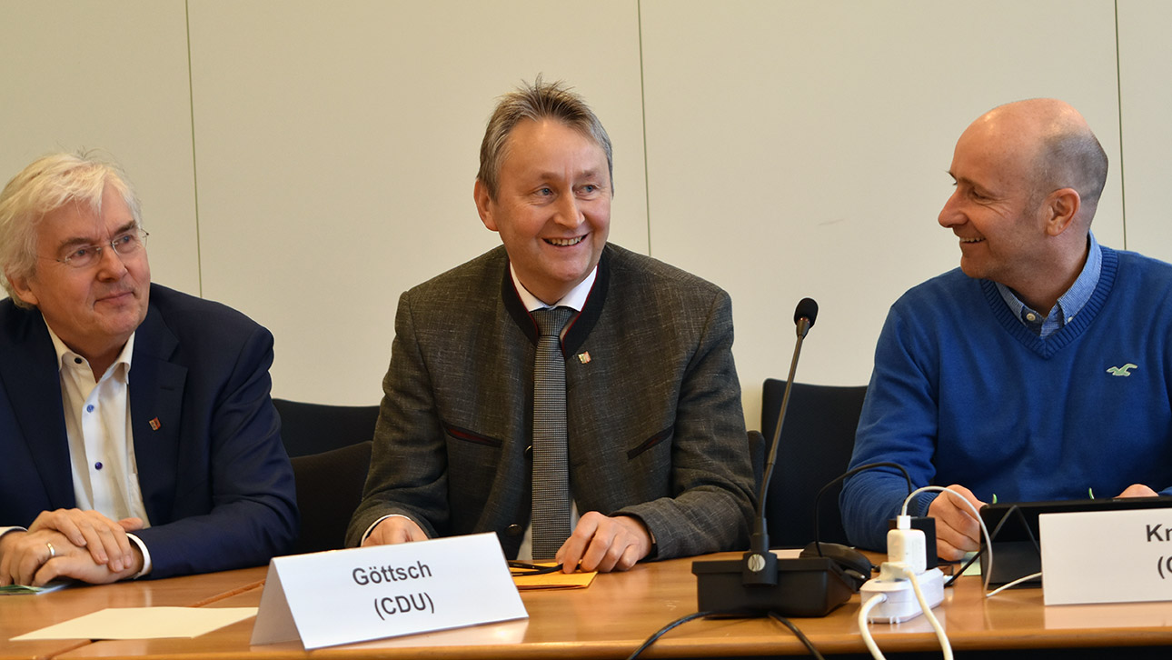 Der CDU-Abgeordnete Hauke Göttsch freut sich nach seiner Wahl. Neben ihm sitzen die Abgeordneten Bernd Heinemann (SPD) und Peer Knöfler (CDU).