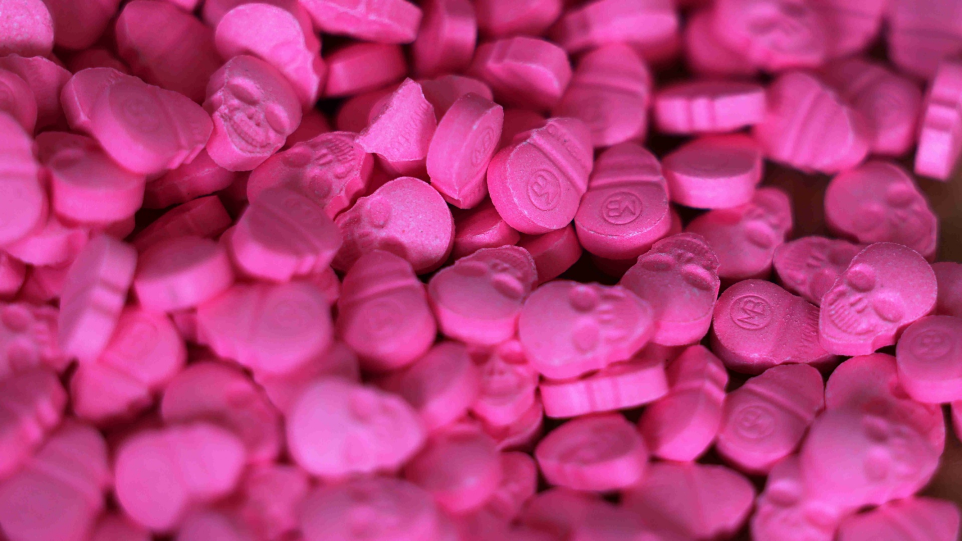 Rosane Ecstasy-Tabletten mit einem aufgedruckten Totenkopf