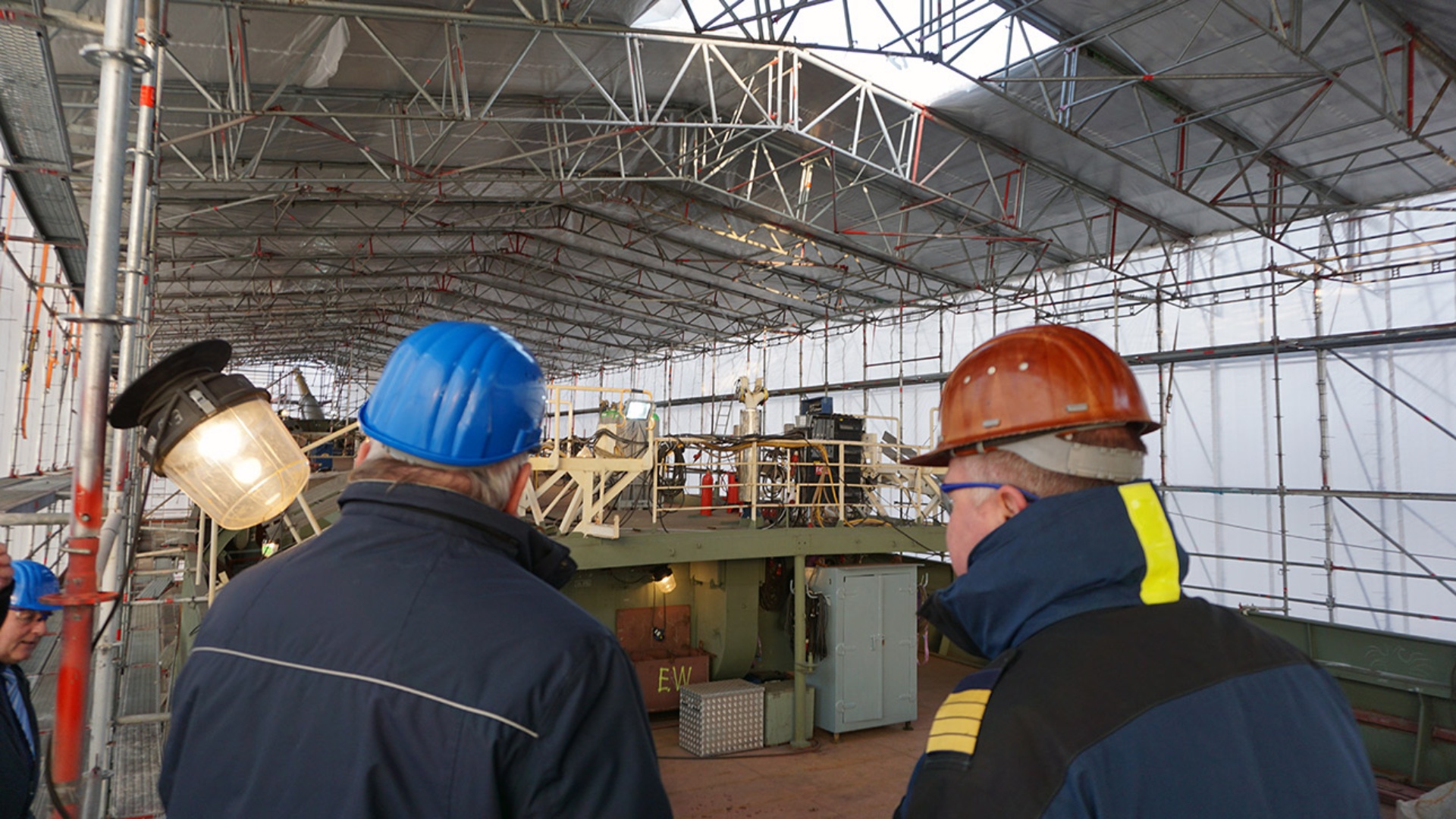Landtagspräsident Klaus Schlie blickt vom Gerüst in die Baustelle des Segelschulschiffes Gorch Fock