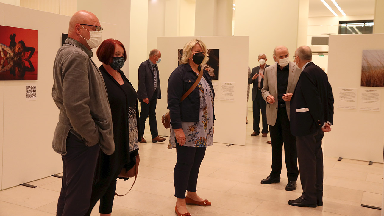 Besucher betrachten Porträts von Menschen, die für die Ausstellung fotografiert wurden.