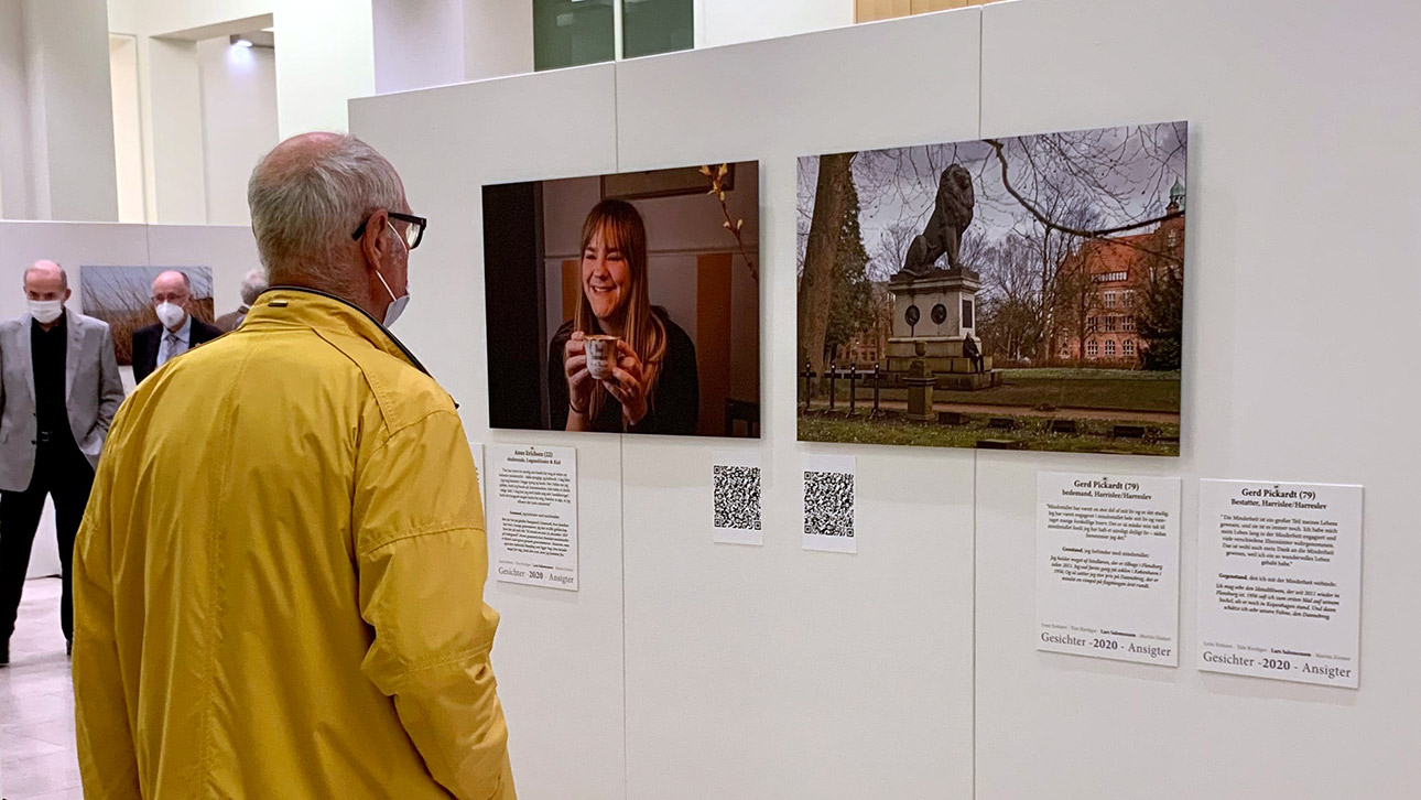 Ein Besucher betrachtet Porträts von Menschen, die für die Ausstellung fotografiert wurden.