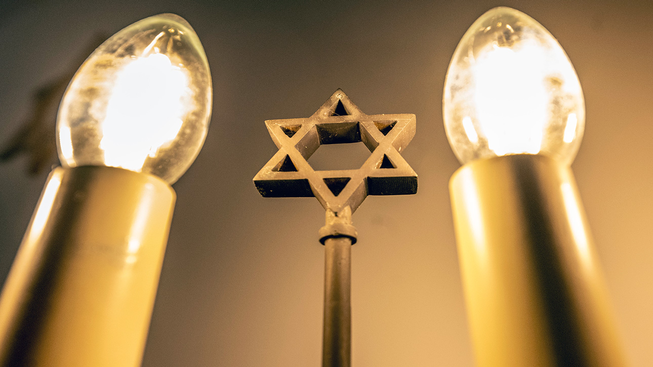 Ein siebenarmiger Leuchter (Menora) mit einem Davidstern in der Mitte leuchtet im Gebetsraum in der Neuen Synagoge.