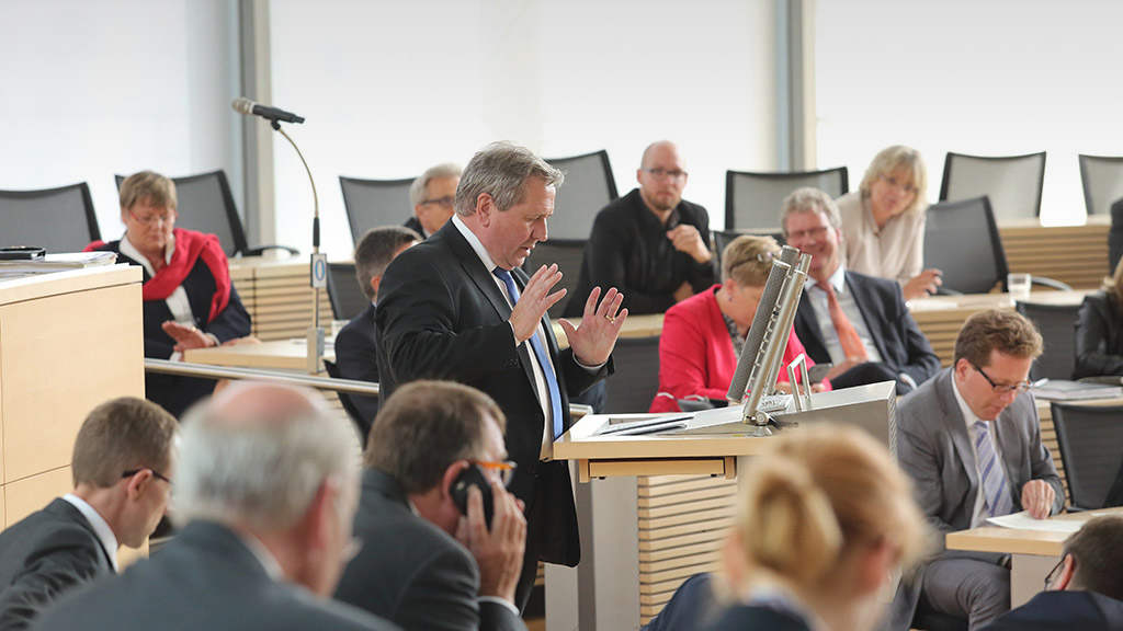 Ein Redner am Redepult im Plenarsaal des Schleswig-Holsteinischen Landtages