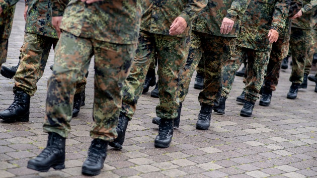 Beide und Stiefel marschierender Soldaten in Tarnuniformen