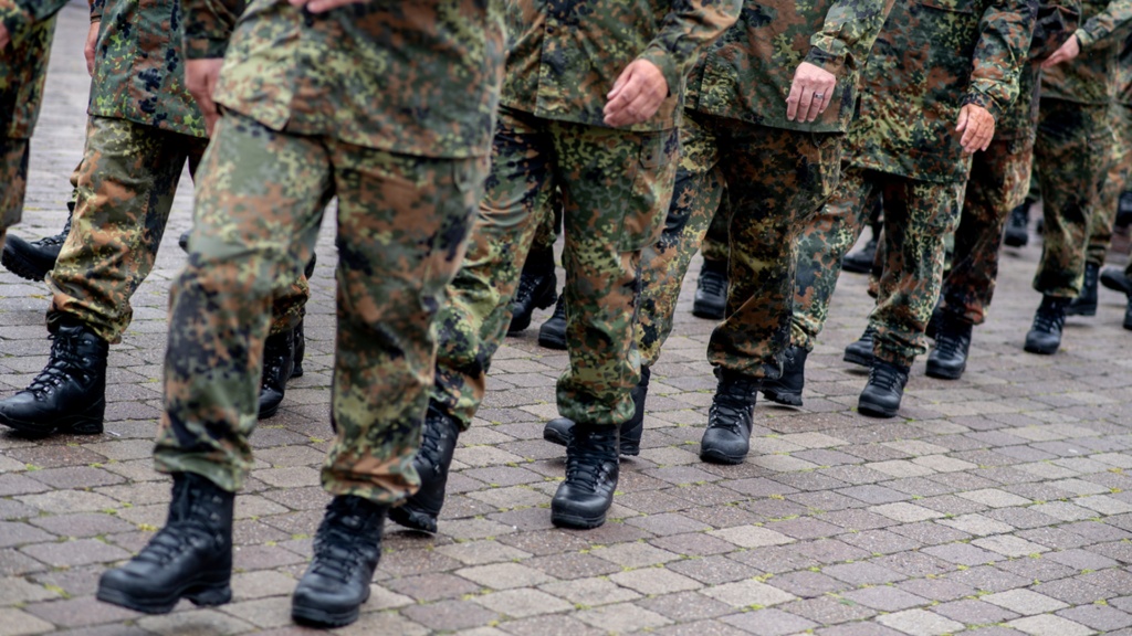 Beide und Stiefel marschierender Soldaten in Tarnuniformen