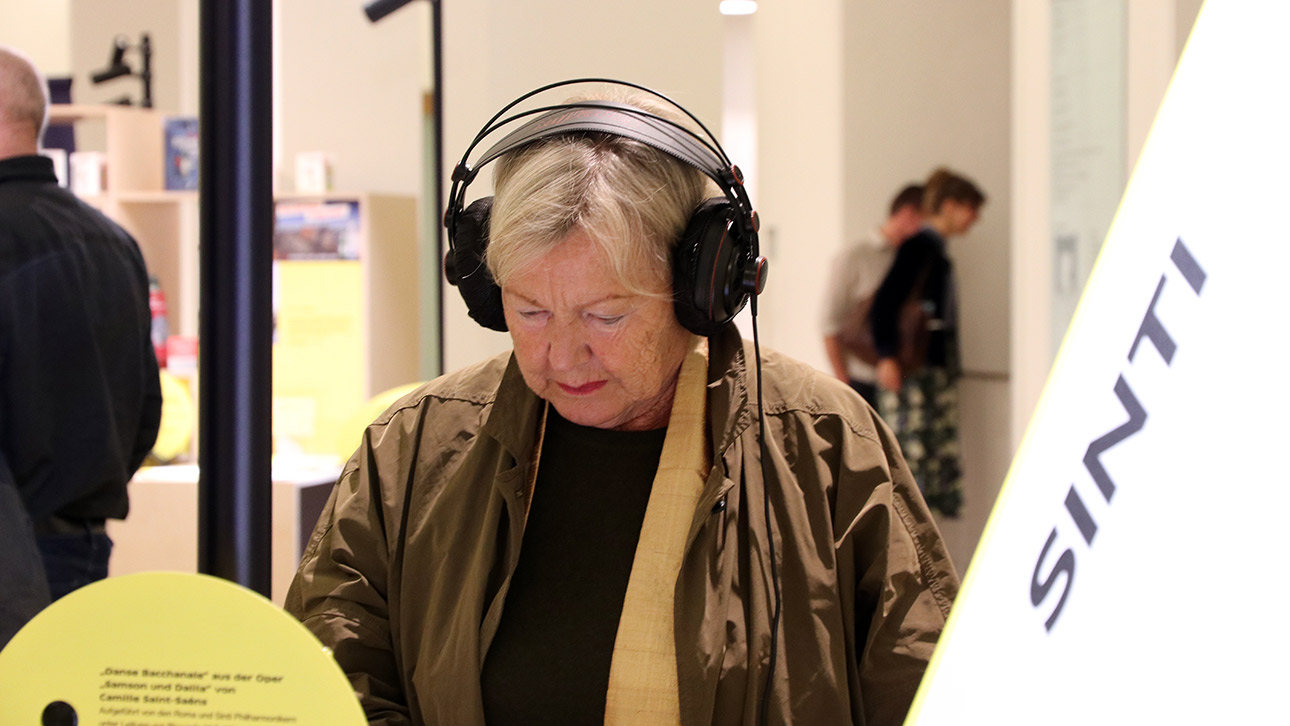 Eine Besucherin nutzt eine der Audiostationen der Ausstellung.