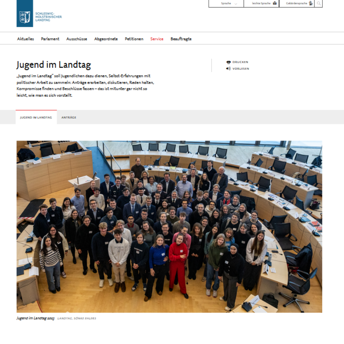 Screenshot der verlinkten Seite, am größten ist ein Gruppenbild der Veranstaltung abgebildet