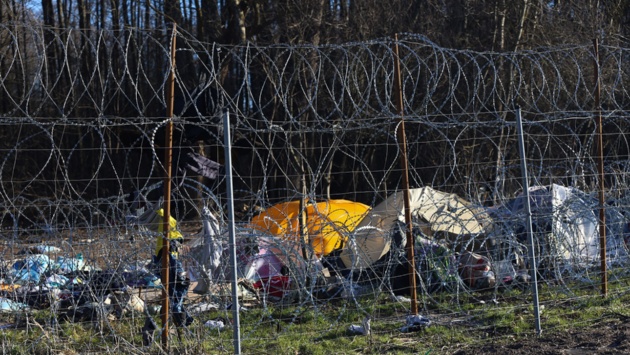 Die Reste eines verlassenen Zeltlagers von Migranten stehen in der Nähe des polnischen Ortes Usnarz Gorny auf der belarussischem Seite der Grenze. Davor der Stacheldrahtverhau, den Polen an der EU-Außengrenze zu Belarus errichtet hat.