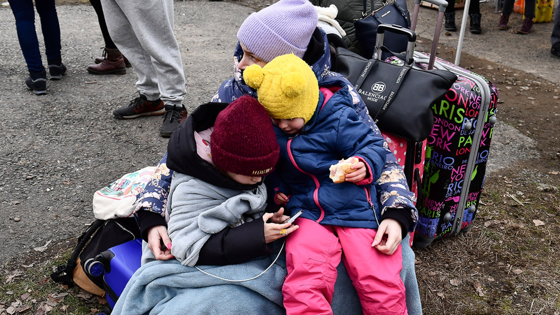 Eine Frau umarmt zwei Kinder an einem von örtlichen Freiwilligen betriebenen Kontrollpunkt, nachdem sie vor dem Konflikt in der Ukraine geflohen sind.